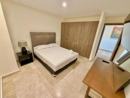 ein Schlafzimmer mit einem Bett, einem Tisch und einem Fenster in der Unterkunft Central 102 Malecón in Mazatlán