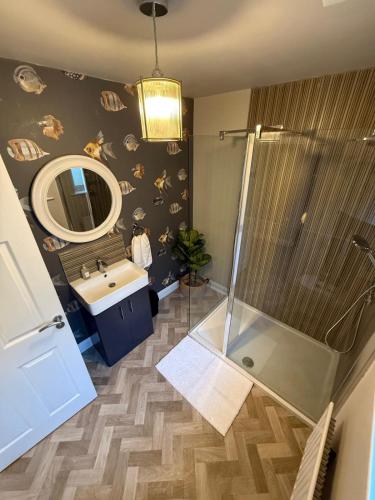 a bathroom with a shower and a sink and a mirror at Derry City Centre Townhouse in Derry Londonderry