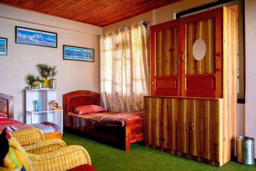 a bedroom with a bed and a large window at Bethany Homestay in Kalimpong