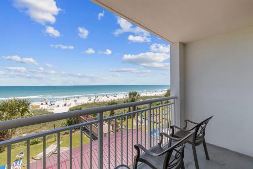 a balcony with two chairs and a view of the beach at Camelot by the Sea Oceanfront 2BR in Myrtle Beach