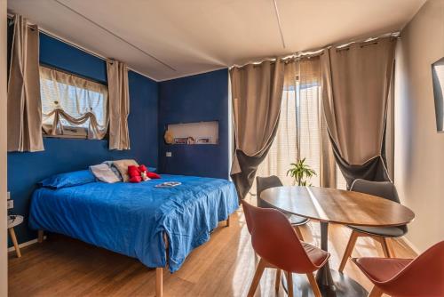 a bedroom with blue walls and a bed and a table at B&B Sentiero Rusca in Sondrio