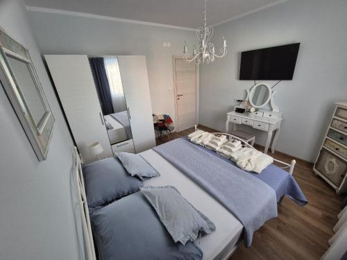 a bedroom with two beds and a mirror and a television at Villa Susann in Šibenik