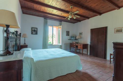 Agriturismo Il Pettirosso في فورلي: غرفة نوم بسرير كبير بسقف خشبي