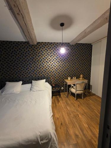 a bedroom with a bed and a table with a chair at Maison village in Sérignan