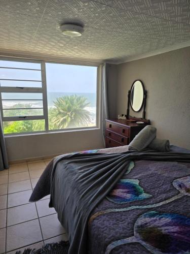 a bedroom with a bed and a mirror and a window at Unit 9 The Beachfront in Ramsgate