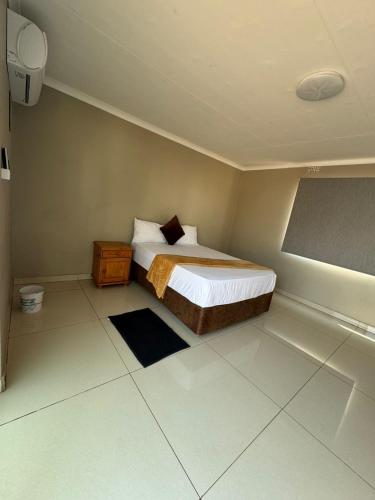 a bedroom with a bed and a table in it at JandJ Guest House in Armburg