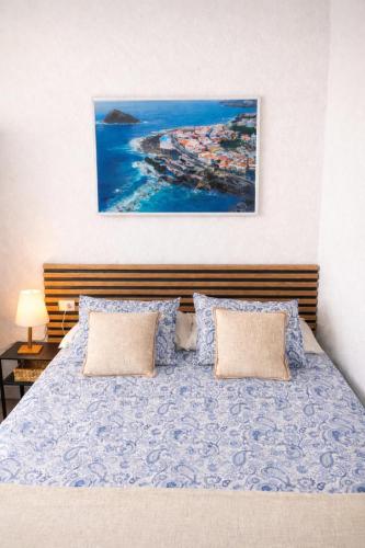 a bedroom with a bed with a painting on the wall at Alma Del Sur Tenerife in Arona