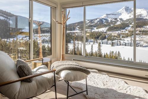 a living room with a view of a snowy mountain at North Summit in Big Sky