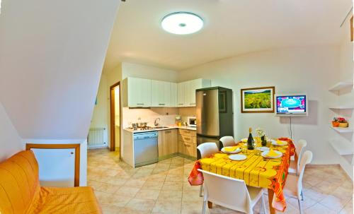 a kitchen and dining room with a table and chairs at Villaggio Mare Blu in Bibione