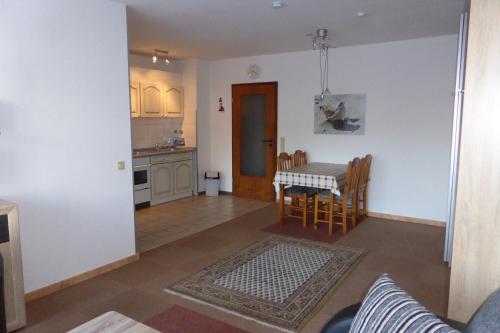Una sala de estar y una cocina con mesa y sillas. en Villa am Meer (Ostsee), en Grömitz