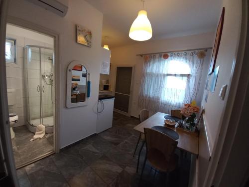 a bathroom with a shower and a table and a kitchen at Bella Badacsony Apartmanház in Badacsonytomaj