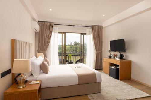 a hotel room with a bed and a television at Royal Avenue Kandy in Kandy