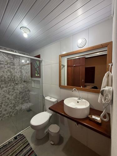 a bathroom with a toilet and a sink and a shower at Pousada Chalés Jatobá in Prados