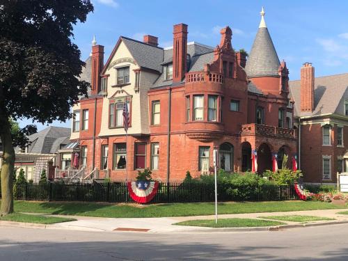 a large red brick house with a roof at Schuster Mansion Bed & Breakfast in Milwaukee
