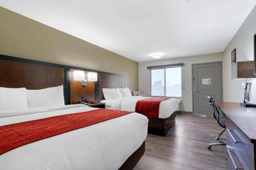 a hotel room with two beds and a desk at Antioch Inn and Suites in Antioch