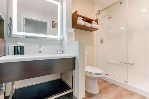 a bathroom with a sink and a toilet and a shower at Antioch Inn and Suites in Antioch