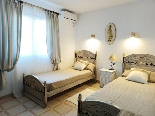 a bedroom with two beds and a window at Casa Luna Llena in Calpe