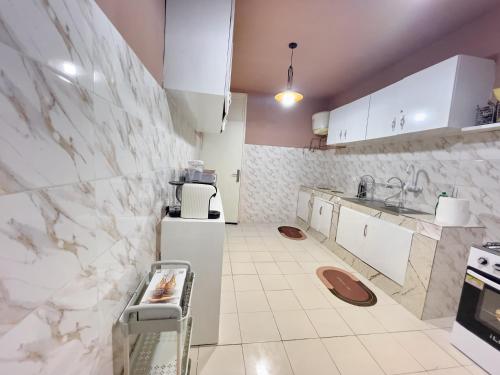 a kitchen with white counters and white appliances at Bohemian & White Getaway Zone4 in Abidjan