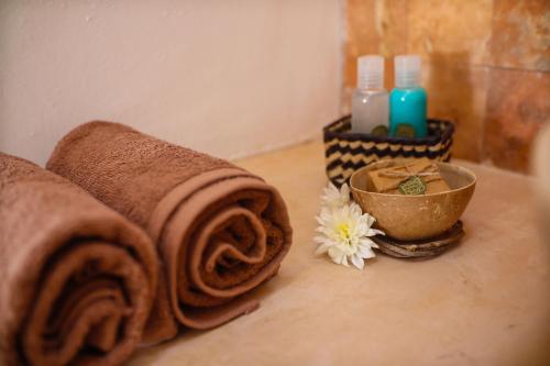 a bathroom with towels on a counter with a bowl at Hotel Aldea Katún in Izamal