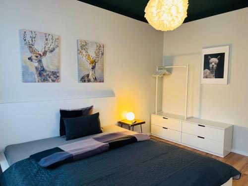 ein Schlafzimmer mit einem großen Bett und einem Kronleuchter in der Unterkunft White Inn - Statement in Mürzzuschlag