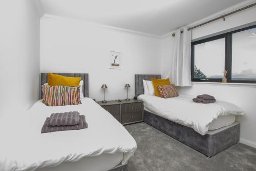 two beds in a room with a window at Lewis Living in Isle of Lewis