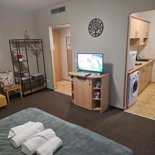a room with a bed and a computer on a desk at Karos Kristály Apartman in Zalakaros