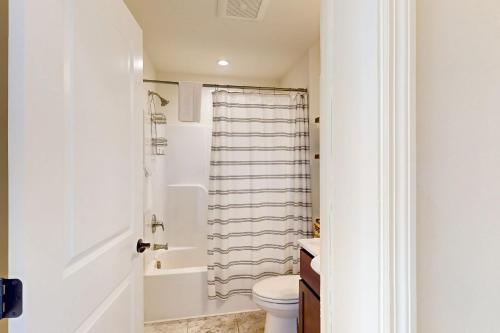 a white bathroom with a toilet and a shower at Schroon Lake Retreat in Schroon Lake