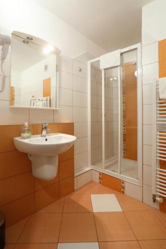 a bathroom with a sink and a shower at Hotel Strážnice in Strážnice