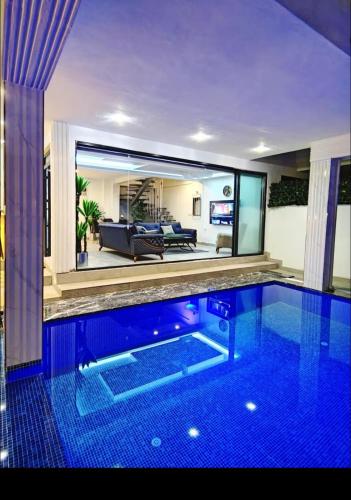 a swimming pool in a house with a large mirror at My Palace Villa Heated Pool in Belek