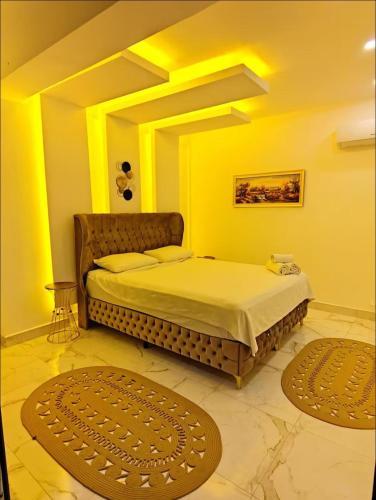 a bedroom with a bed with yellow walls and two rugs at My Palace Villa Heated Pool in Belek