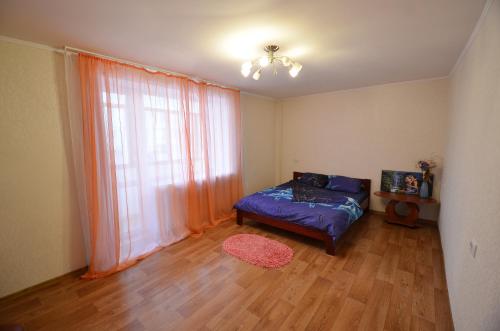 ein Schlafzimmer mit einem Bett und einem großen Fenster in der Unterkunft Apartment on Navarynska in Mykolajiw
