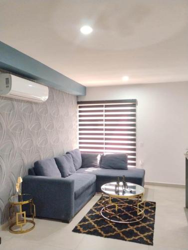 a living room with a blue couch and a table at Apartment with lagoon view mas amenities in Mazatlán