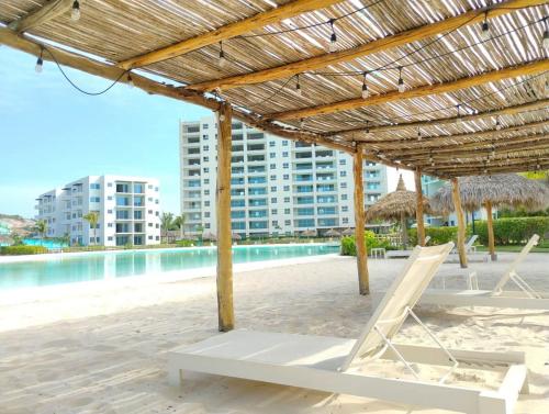 a beach with chairs and umbrellas and a pool at Apartment with lagoon view mas amenities in Mazatlán