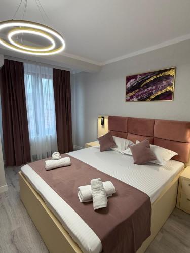 a bedroom with a large bed with two towels on it at MavCity Boutique in Constanţa