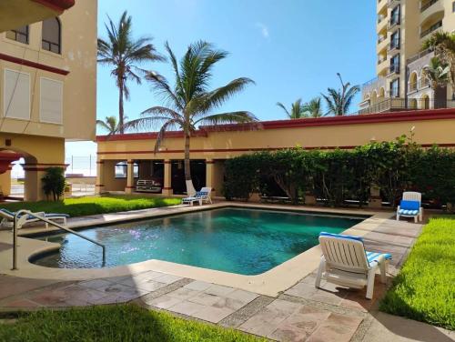a swimming pool in front of a building at Comfortable apartment, right on the seafront in Mazatlán