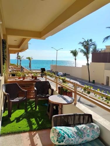 a patio with a table and chairs and the ocean at Comfortable apartment, right on the seafront in Mazatlán