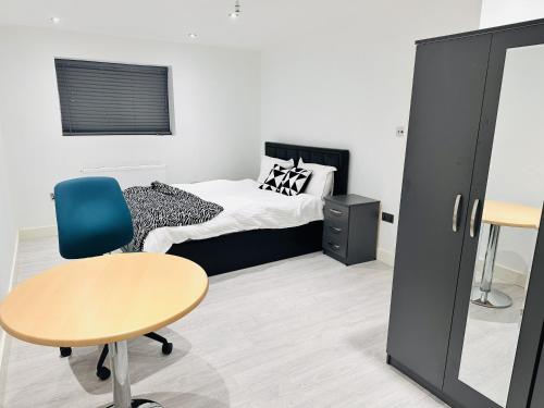 a bedroom with a bed and a table and a desk at Large Double Bed En-suite Room 20 mins from Heathrow in Burnham