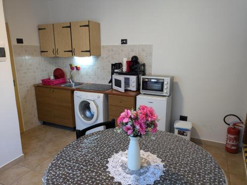 a kitchen with a table with a vase of flowers on it at Il Nido sul Torrente in Coazze