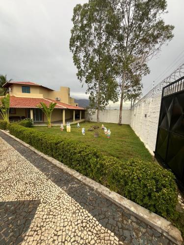 a house with chickens sitting in a yard at Chácara Rbs in Sobral