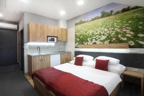 a bedroom with a bed and a painting on the wall at Hotel Strážnice in Strážnice