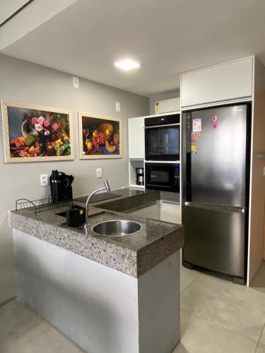 a kitchen with a sink and a refrigerator at Flat aconchegante em Recife in Recife