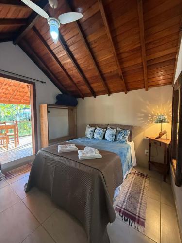 a bedroom with a bed and a ceiling fan at Pousada Chalés Jatobá in Prados