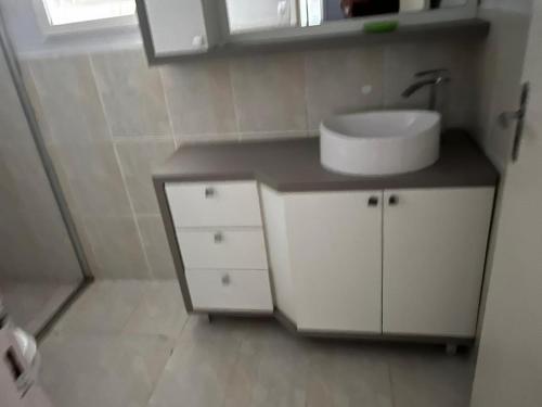 a bathroom with a white sink and a mirror at Xangri-lá Beach House in Xangri-lá