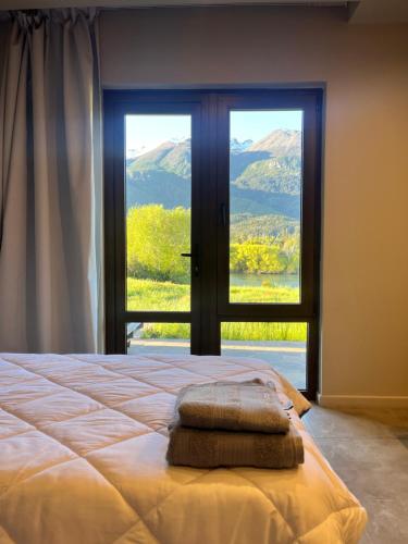 a bedroom with a bed and a large window at Límite Sur Lodge in Trevelín