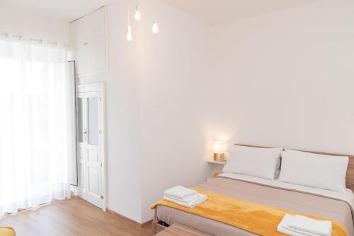 a white bedroom with a bed and a window at Don Sturzo Apartment in Caltagirone