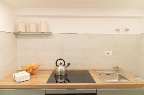a kitchen counter with a tea kettle on a sink at Don Sturzo Apartment in Caltagirone