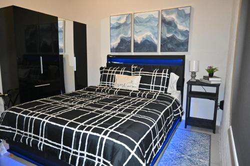 ein Schlafzimmer mit einem schwarz-weißen Bett und Gemälden in der Unterkunft Tiny Space, Big Comfort in Tampa
