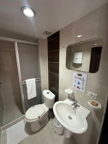 a bathroom with a sink and a toilet and a shower at Hotel Royal Suite in Manizales