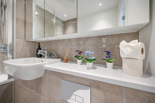 a bathroom with a sink and a mirror at Executive 3-Bed 2-Bath Apartment Central London in North Woolwich