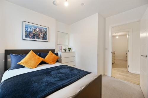 a bedroom with a bed with blue and orange pillows at Executive 3-Bed 2-Bath Apartment Central London in North Woolwich